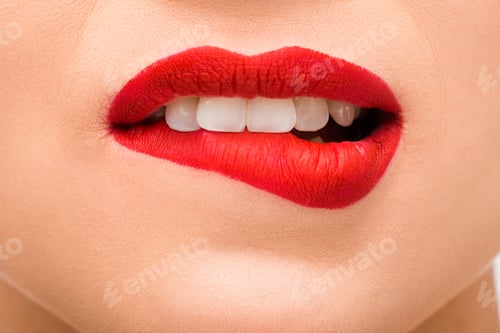 Preview: cropped view of sexy young woman with red lipstick biting lips