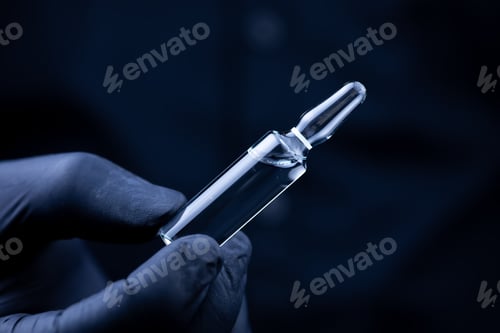 Preview: the hands of a doctor in black medical gloves who turns over an ampoule with a vaccine
