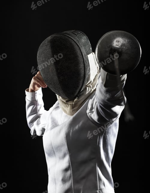 Preview: Portrait of woman wearing white fencing costume practicing with the sword.