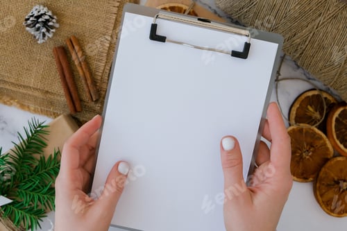 Preview: Woman preparing for christmas holidays. Writing gift list. Box with New Year's gifts, wrapped in cra