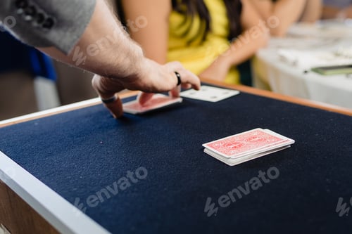 Preview: A magician performs a trick with cards face down on a mat.