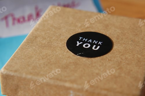 Preview: Gift box with thank you sticker on table