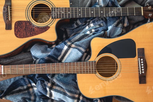 Preview: Two acoustic guitars on a cozy plaid, top view.