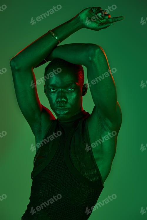 Preview: A stylish young man poses confidently under vibrant green lights, embodying artistry and attitude