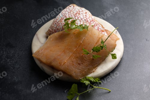 Preview: Whole raw red snapper fish on a cutting board.