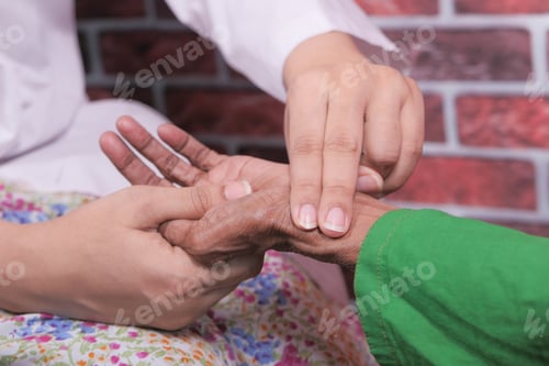Preview: female doctor measuring pulse of elderly women