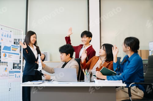 Preview: Group of diverse businesspeople using a laptop and tablet in office.