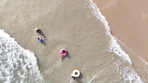 Preview: Happy children playing together in the sea, enjoying a fun summer day at the beach