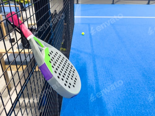 Preview: paddle tennis racket and balls on the blue paddle court