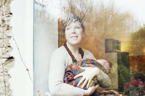 Preview: Mother with baby looking out of window