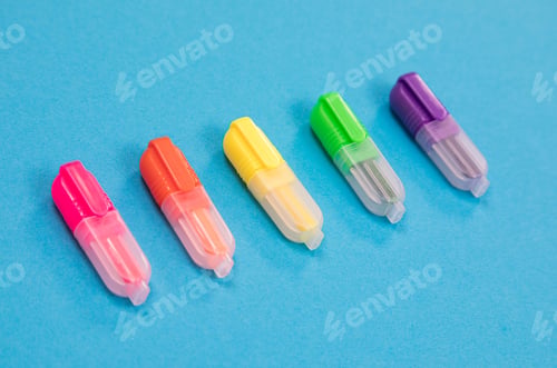 Preview: Five small multicolored highlighters on azure background isolated