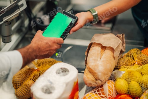 Preview: Customer paying with smartphone at grocery store checkout