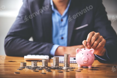 Preview: businessman holding a coin in a piggy bank On a table with sunlight. Money Saving Ideas for Financia