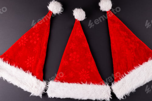 Preview: Image of santa claus hats lying on dark grey surface