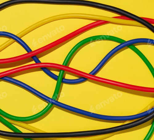 Preview: Multicolored rubber tubes on a yellow background, top view