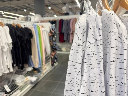 Preview: clothing store displays casual black, white, and patterned garments on racks