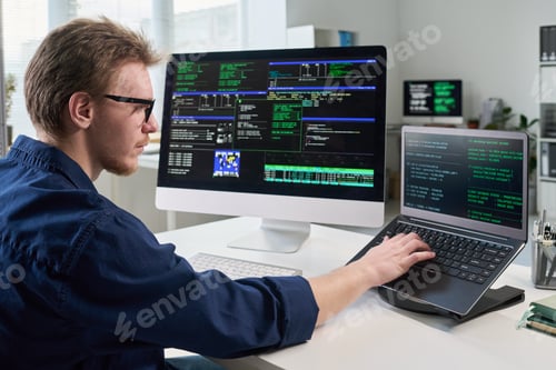 Preview: Young Man Working on Computer and Laptop in Office