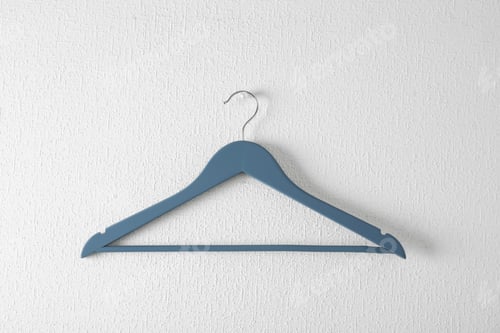 Preview: Empty clothes hanger on light wall. Wardrobe accessory