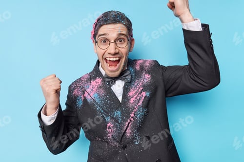 Preview: Optimistic man celebrates promotion at work makes triumph gesture exclaims gladfully dressed in fest
