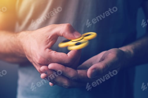 Preview: Yellow fidget spinner in male hand