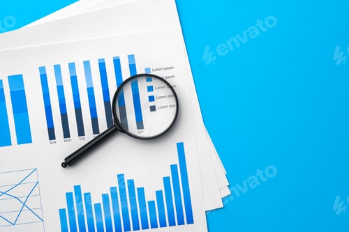 Preview: Business graphs and magnifying glass on table
