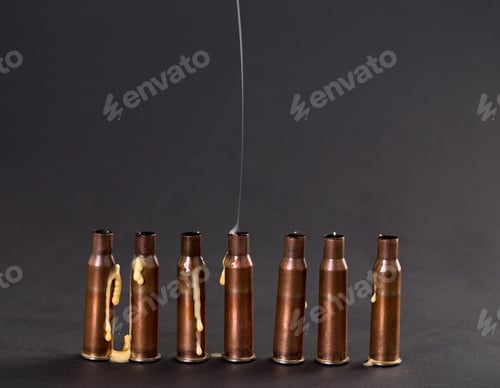 Preview: Empty rifle cartridges with melted candles.