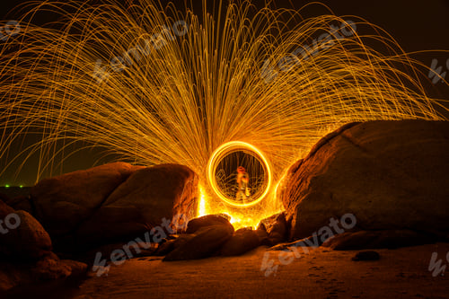 Preview: Fire dancing show swing lighting effects circle on bridge dark sky on night time.