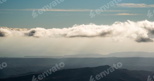Preview: Cloudy sky with cumulus clouds above mountain cliffs. Moody atmosphere
