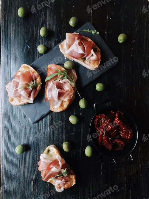 Preview: Appetizing bruschetta with green olives on wooden table