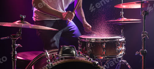 Preview: The drummer plays the drums. Beautiful blue and red background, with rays of light.