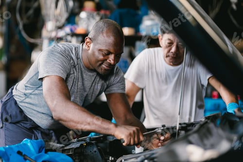 Preview: Mechanic team men working together to service fix engine problem in car auto workshop