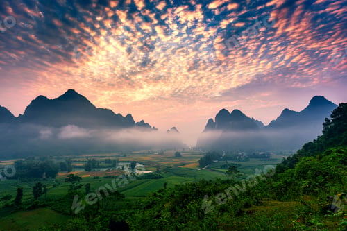 Preview: Landscape of vibrant sunrise over mountain range with foggy, river and traditional village