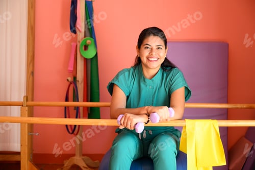 Preview: Portrait of Smiling physiotherapist holding weights in rehabilitation center