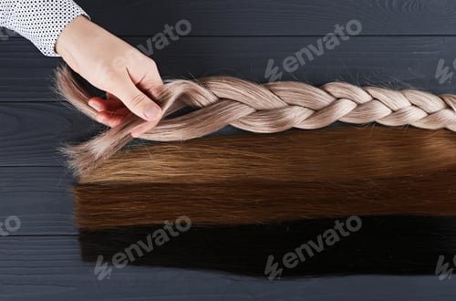 Preview: Man holds by his hand different types of hair for extensions.