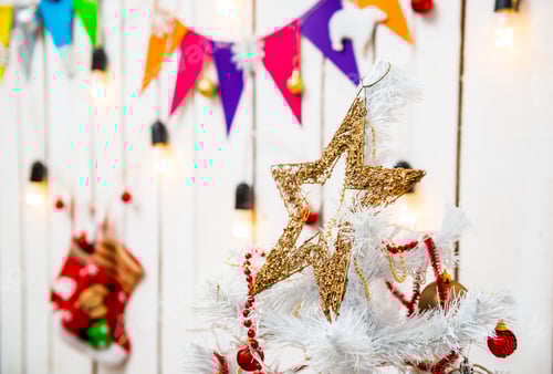 Preview: toy star on top of christmas tree in decorated room