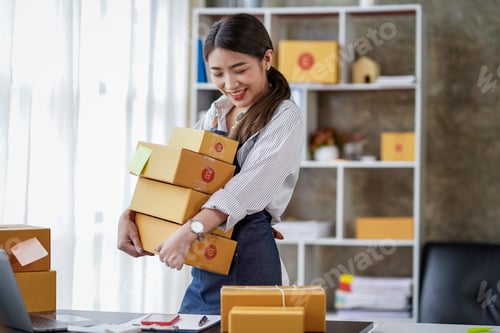 Preview: Attractive Asian businesswoman checking items before sending them to customers. Young Asian small bu