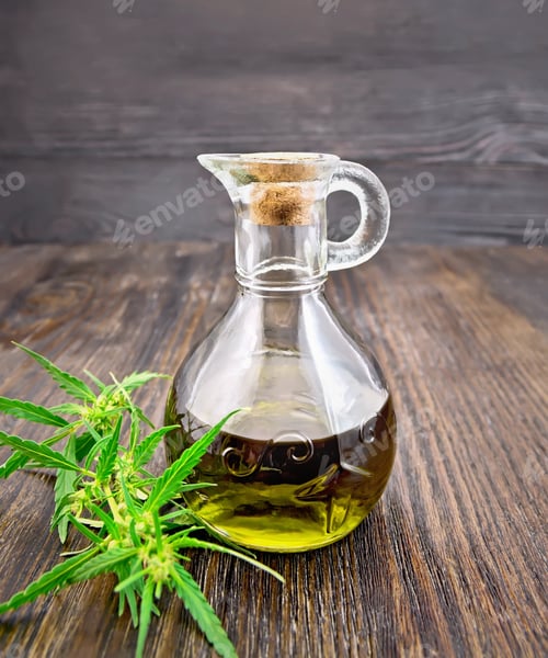 Preview: Oil hemp in glass decanter on dark board