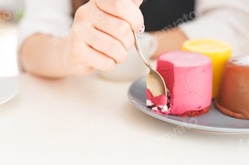 Preview: Woman’s hand who eating cakes and desserts