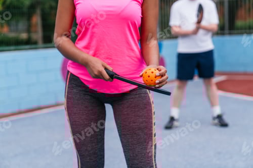 Preview: Unrecognizable woman holding pickleball paddle and ball, getting ready to serve