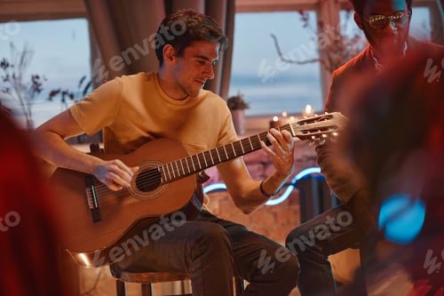 Preview: Man playing guitar for his friends