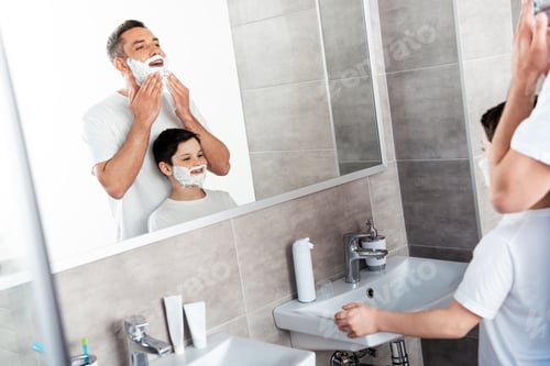 Preview: son and father with shaving cream on faces in bathroom