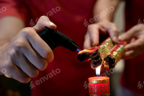 Preview: Hand holding joss sticks and candle as prayer and offering to the Gods