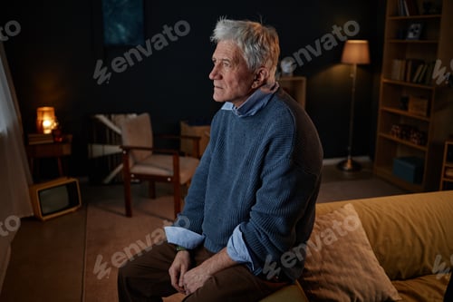 Preview: Sitting Elderly Man in Sweater Looking Thoughtful