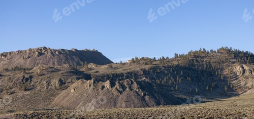 Preview: Dry rocky desert mountain landscape with trees.
