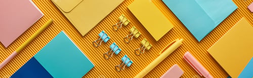 Preview: panoramic shot of colorful arranged office stationery supplies on yellow