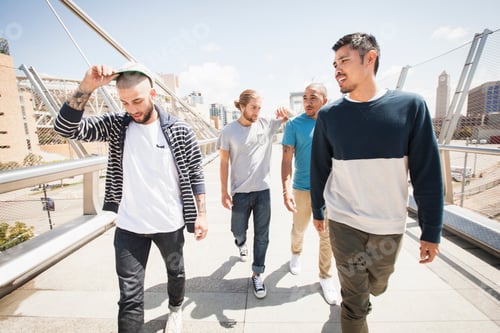Preview: Group of young men walking along a bridge.