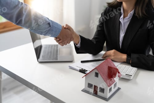 Preview: Real estate agents and customers shake hands to congratulate on signing a contract to buy a house