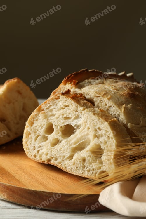 Preview: Board with fresh bread on white wooden background