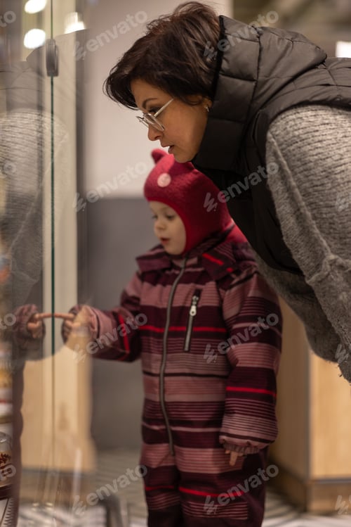 Preview: Mom and child near the shop window choose what to buy