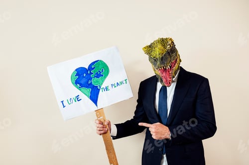 Preview: Man with a lizard head in studio WITH cardboard sign that says I LOVE THE PLANET